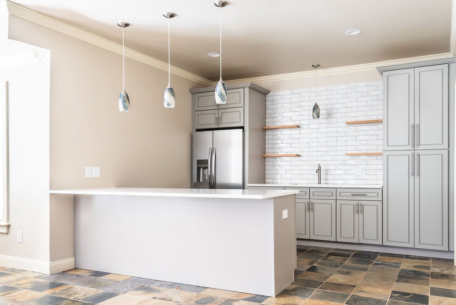 A bright finished basement living space with white cabinetry and an island