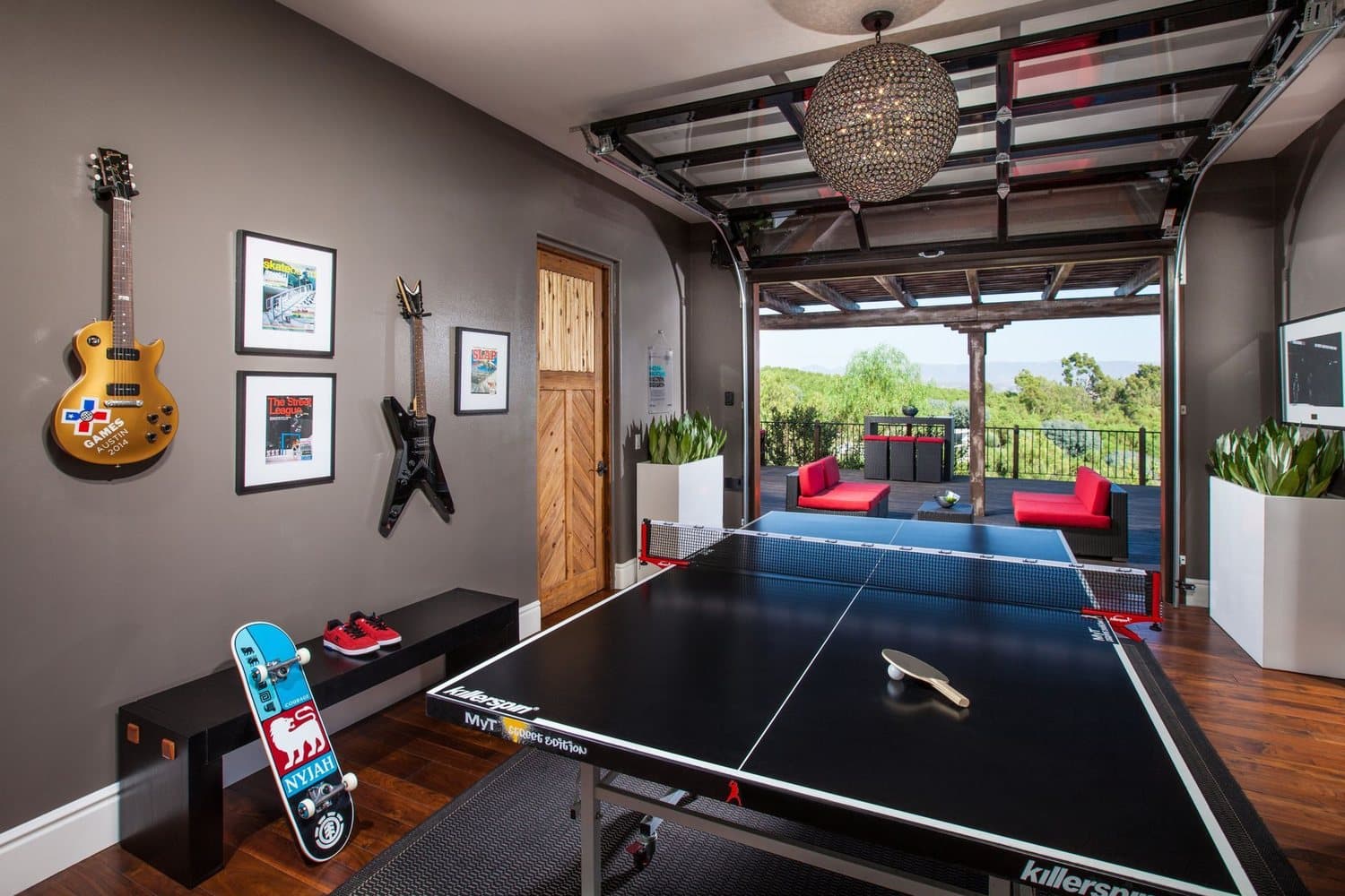 Basement game room with a ping-pong table and guitars on the wall