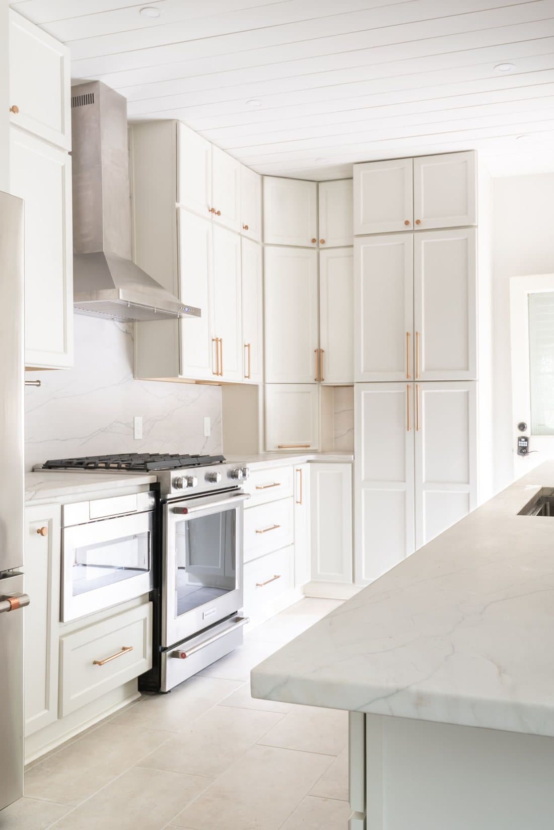 Custom basement kitchenette with white cabinets and quartz counters