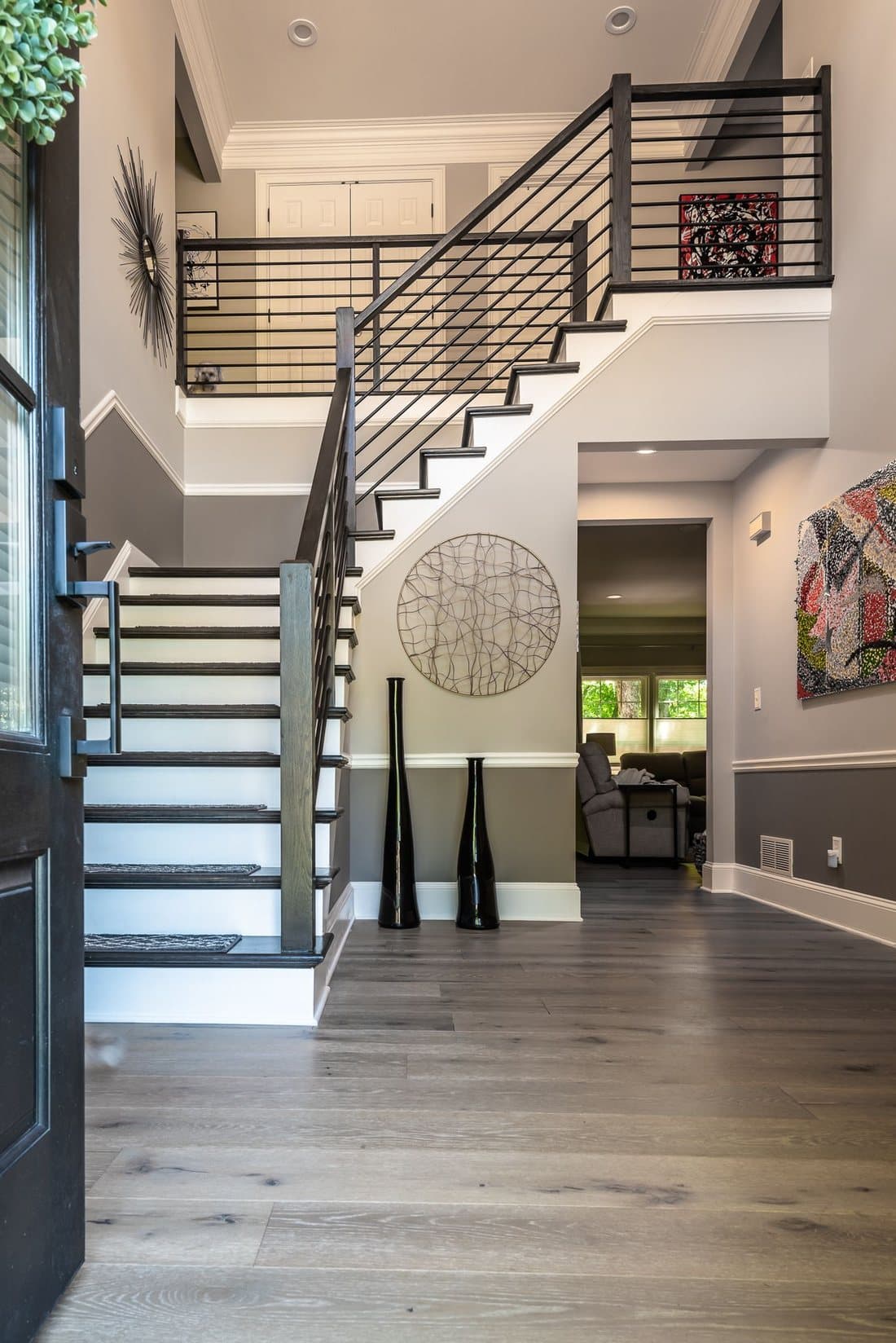 Open finished basement with a modern staircase and railings